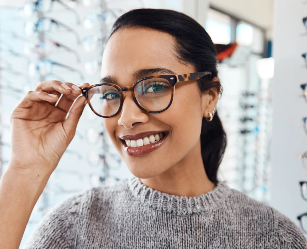 Woman smiling while choosing eyeglass frames